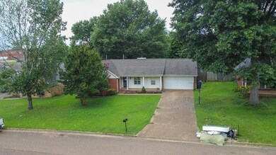 Single story home with concrete driveway, a garage, and roof with shingles