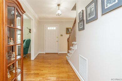 Wood floored foyer featuring ornamental molding