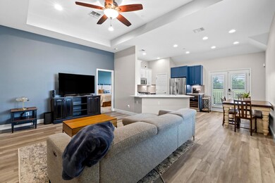 Living room with a ceiling fan, light wood-style 