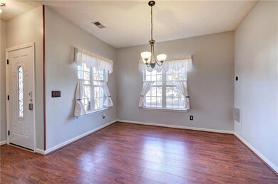 Entrance foyer off the dining room with a chandelier, plenty of natural light, LVP flooring