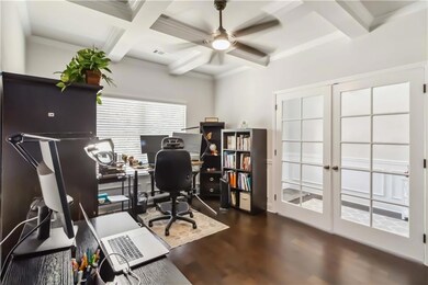 Office area with ceiling fan, dark wood finished floors, beamed ceiling, coffered ceiling, and ornamental molding