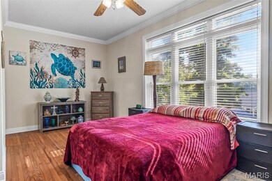 Bedroom featuring ornamental molding, hardwood / wood-style floors, and ceiling fan