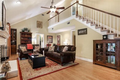 Living area has vaulted ceiling and balcony leading to 2 beds and bath upstairs