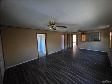 Unfurnished living room with dark wood-style floors and ceiling fan
