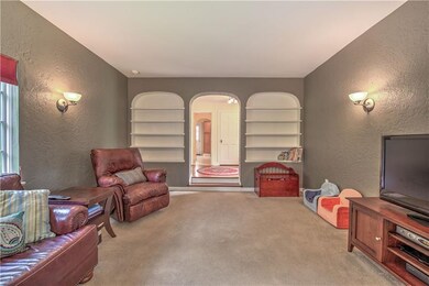 Built-in arching bookshelves delightfully flank the living room's arching entryway.