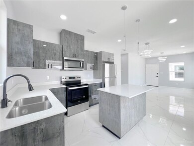Kitchen with gray cabinets, a sink, stainless steel appliances, modern cabinets, and marble finish floor