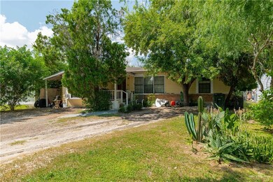 View of property hidden behind natural elements featuring a front yard