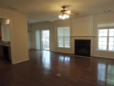 Unfurnished living room with ceiling fan, dark wood-type flooring, a fireplace with raised hearth, baseboards, and a sink