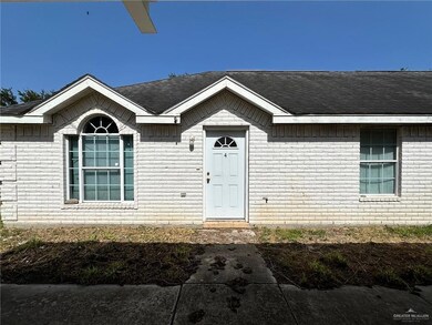 Property entrance with brick siding and a shingled roof