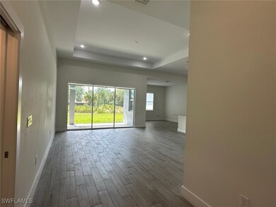 Empty room featuring baseboards, dark wood-style f
