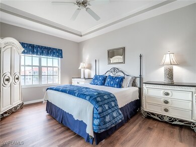 Bedroom with a raised ceiling, crown molding, dark