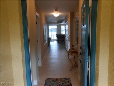Hallway with light tile patterned floors and baseboards