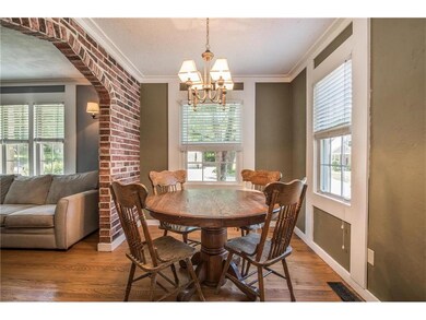 An exposed brick wall with wide tudor archway open