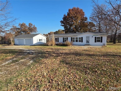 Ranch-style house with an outdoor structure, a garage, and a front yard