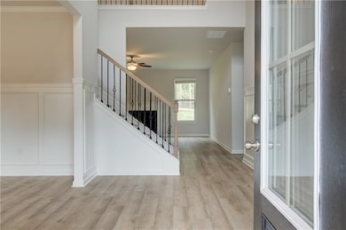 Entrance foyer with ceiling fan and light wood-type flooring