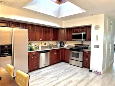 Kitchen featuring stainless steel appliances, recessed lighting, light wood-style flooring, and light stone counters