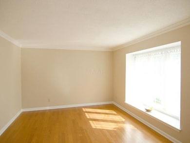 Formal living room with wood floors and lots of li