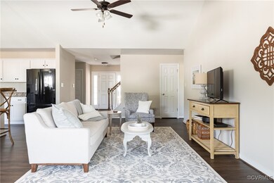 Living room featuring a ceiling fan, stairs, baseb