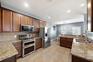 Natural kitchen colors, can lighting, tons of countertops, along with stainless steel finishes helps tie this kitchen together.