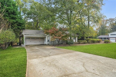 View of front of property featuring a front lawn, concrete driveway, and an attached garage