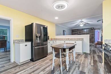 Kitchen featuring wood-type flooring, ceiling fan,