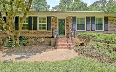 View of front of property with brick siding and a front yard
