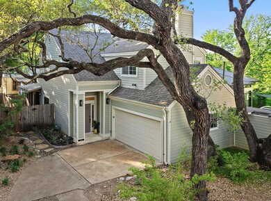 View of front of home with fence, driveway, roof 