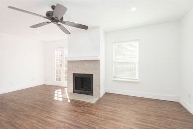 Unfurnished living room featuring dark wood-style floors, a fireplace, and recessed lighting