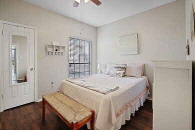 Bedroom with ceiling fan, dark hardwood / wood-sty