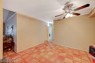 Empty room featuring ornamental molding, ceiling fan, and baseboards