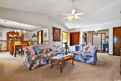 Carpeted living room featuring vaulted ceiling and
