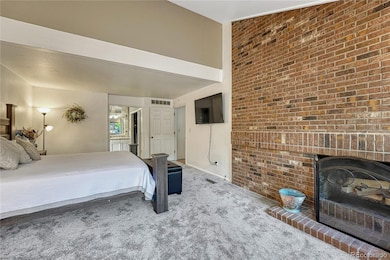 Vaulted ceiling a fireplace in this main floor primary bedroom.