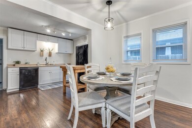 Dining room featuring sink, crown molding, track l