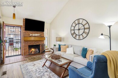Living room featuring vaulted ceiling, brick wall,