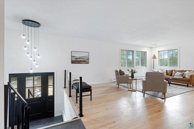 Foyer entrance with light wood-type flooring, baseboard heating, and baseboards