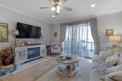 Living area with crown molding, wood finished floo