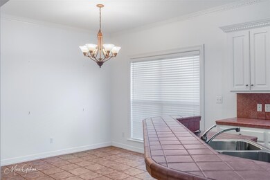 Kitchen with decorative backsplash, crown molding,