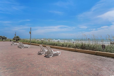 View of patio / terrace with view of water and beach