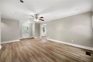 Unfurnished room featuring ornamental molding, ceiling fan, wood finished floors, and recessed lighting