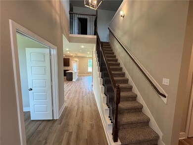 Stairway with a chandelier, wood finished floors,
