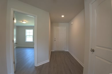 Hall with dark wood-style floors and recessed lighting