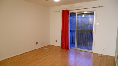 Unfurnished room with wood finished floors and baseboards