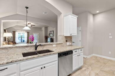Kitchen featuring dishwasher, a sink, light stone