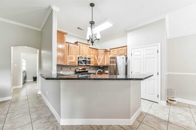 view of kitchen, and down the hall to the laundry room and downstairs bedroom.