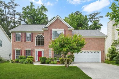 Colonial house with driveway, a front yard, brick front, and a chimney
