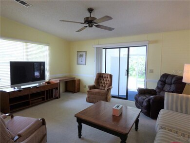 Living room has sliders out to covered screened re