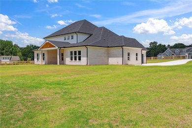 Back of property with brick siding and a shingled roof