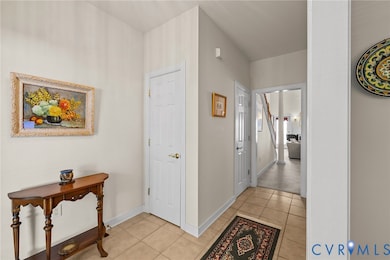 Corridor with light tile patterned flooring and baseboards