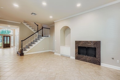 Unfurnished living room with crown molding, a fireplace, recessed lighting, stairway, and light tile patterned floors