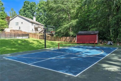 View of basketball court featuring basketball hoop and a storage unit